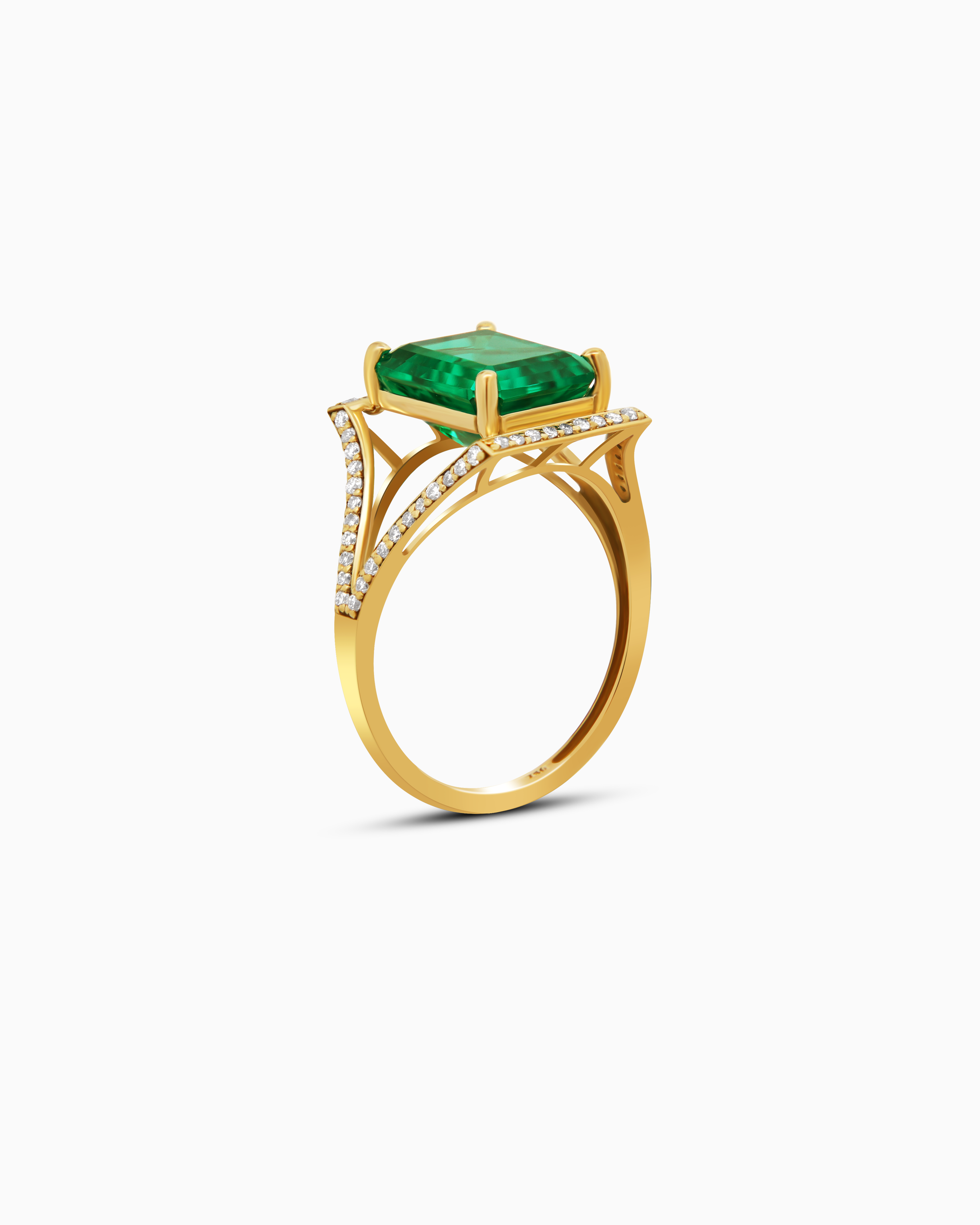 Gold ring with a green gemstone and diamond accents on a white background