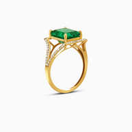Gold ring with a green gemstone and diamond accents on a white background